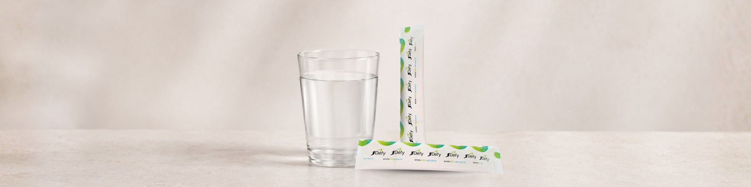 Verre d'eau avec 2 sticks d'électrolytes de la marque 1Defy Nutrition SPortive Made in Bourgogne, pour illustrer l'article de blog : Électrolytes : définition, fonctions, besoins et bénéfices réels