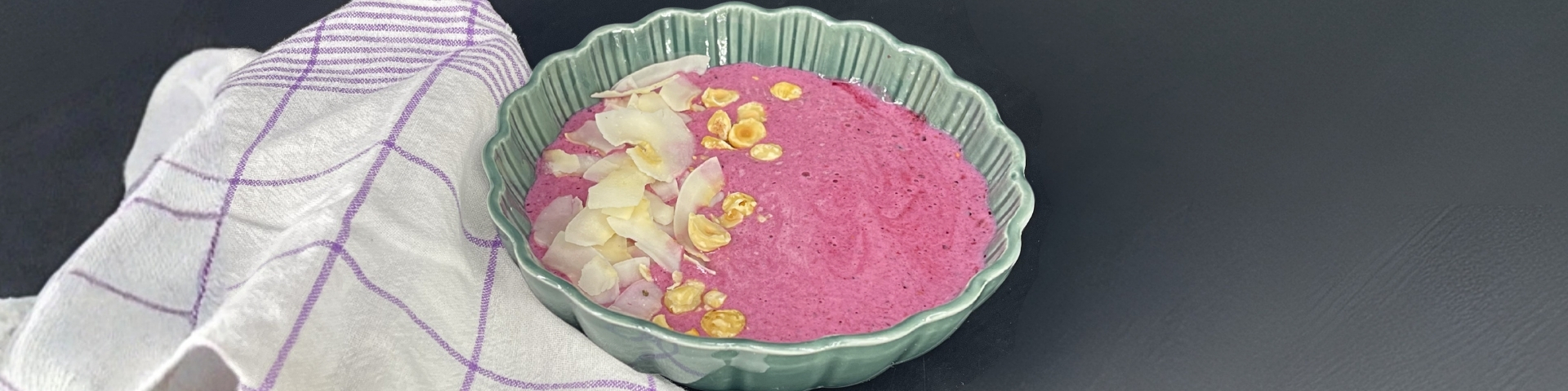 Photo d'un bwol glacé protéiné aux fruits rouges avecde la noix de coco rappée et des noisettes en topping, photo de couverture d'un article blog recette de 1Defy Nutrition Sportive Made in Bourgogne